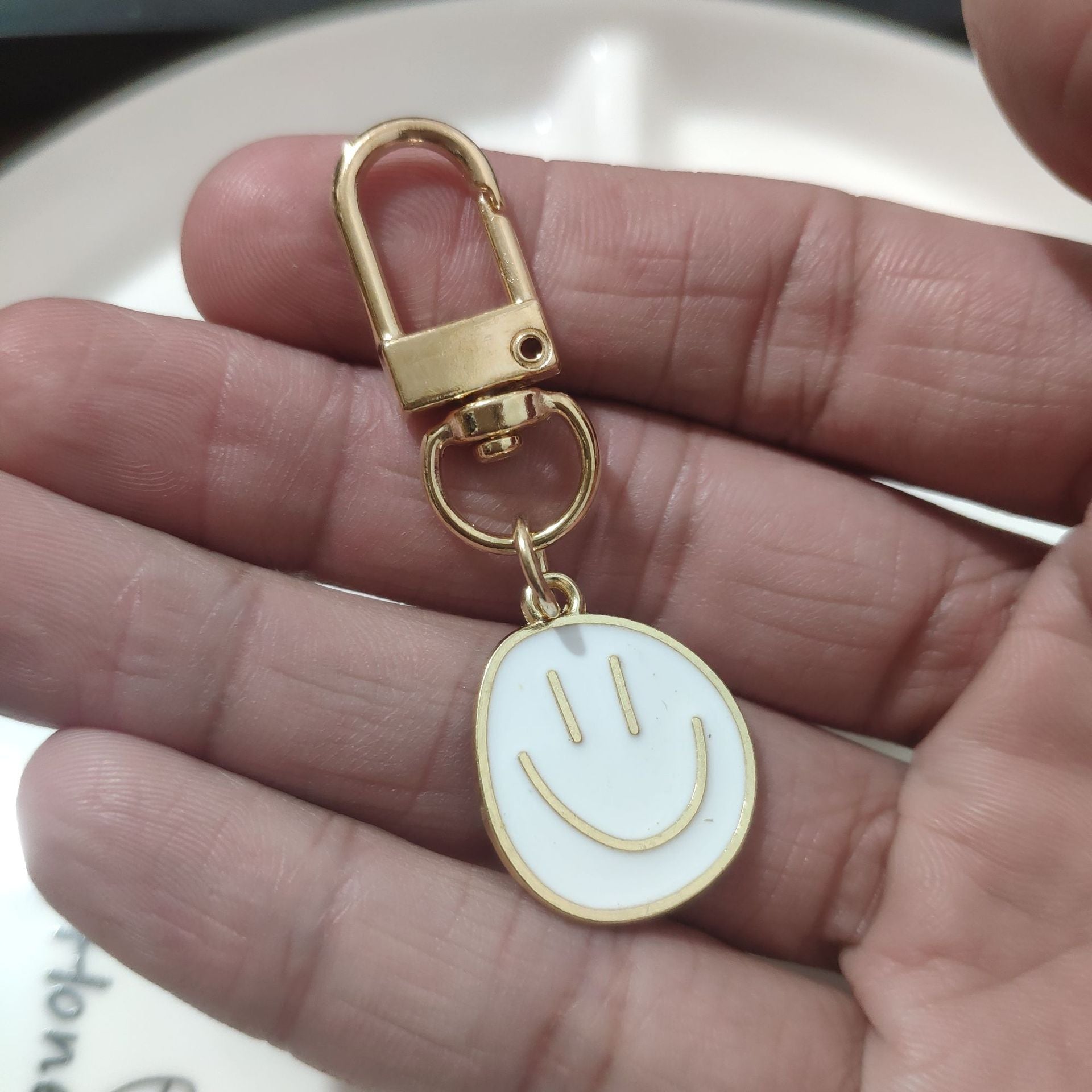 Cross-border e-commerce alloy color dripping smiley face keychain electroplated gold irregular expression bag pendant accessories