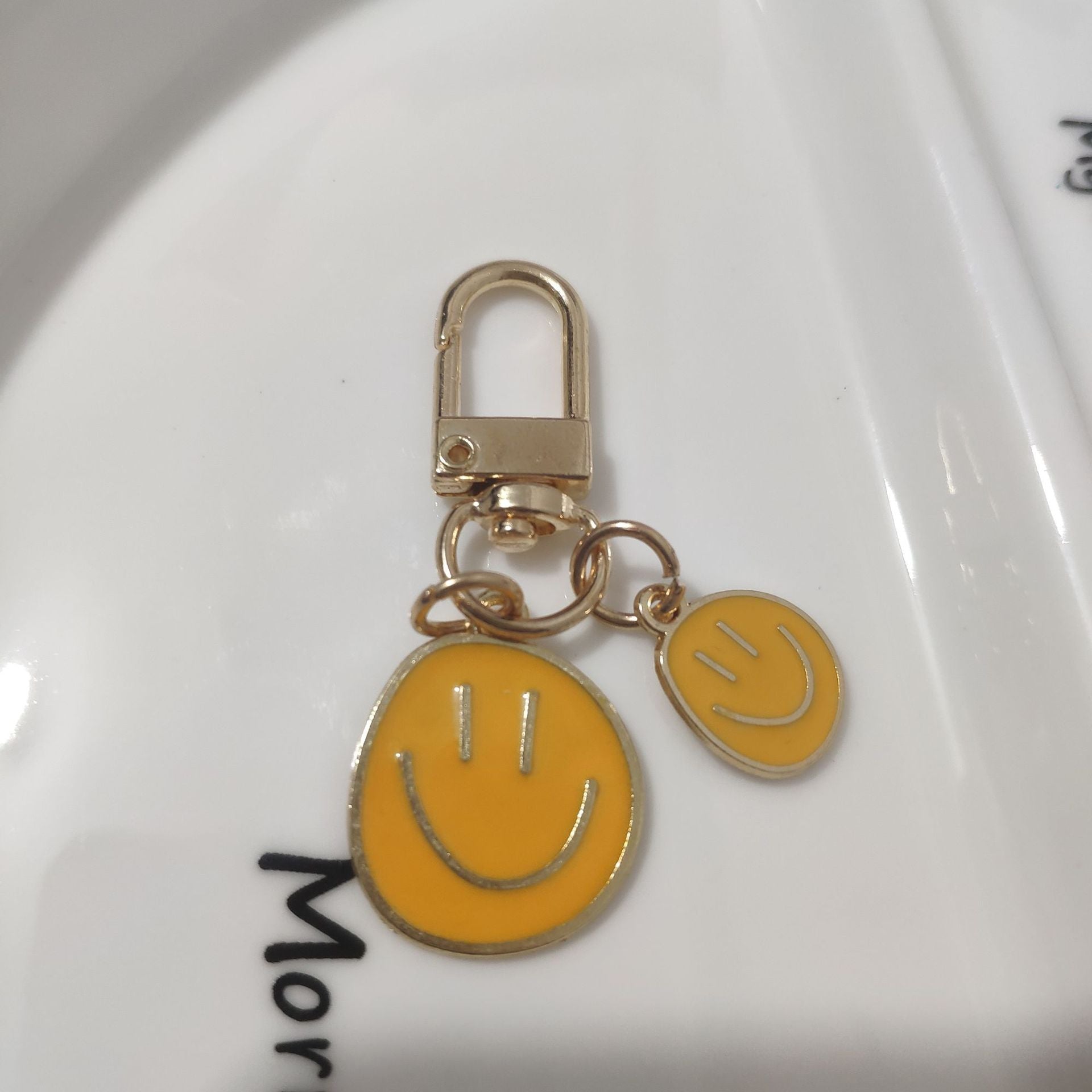 Cross-border e-commerce alloy color dripping smiley face keychain electroplated gold irregular expression bag pendant accessories
