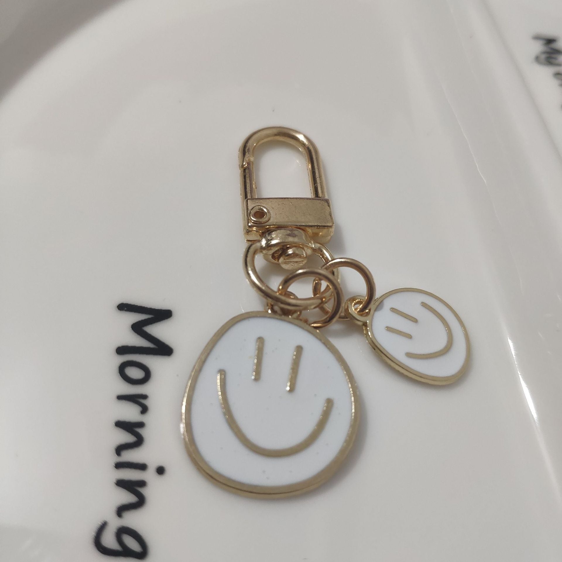 Cross-border e-commerce alloy color dripping smiley face keychain electroplated gold irregular expression bag pendant accessories