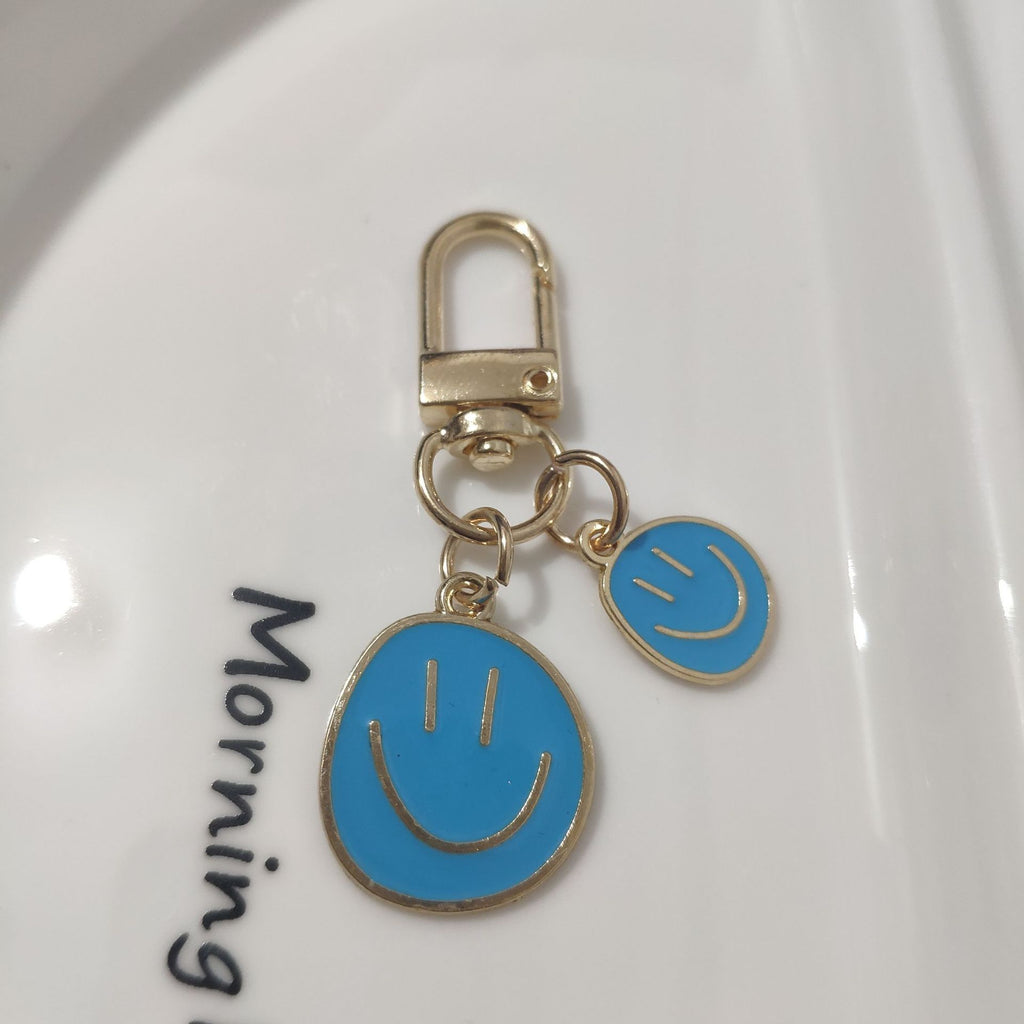 Cross-border e-commerce alloy color dripping smiley face keychain electroplated gold irregular expression bag pendant accessories