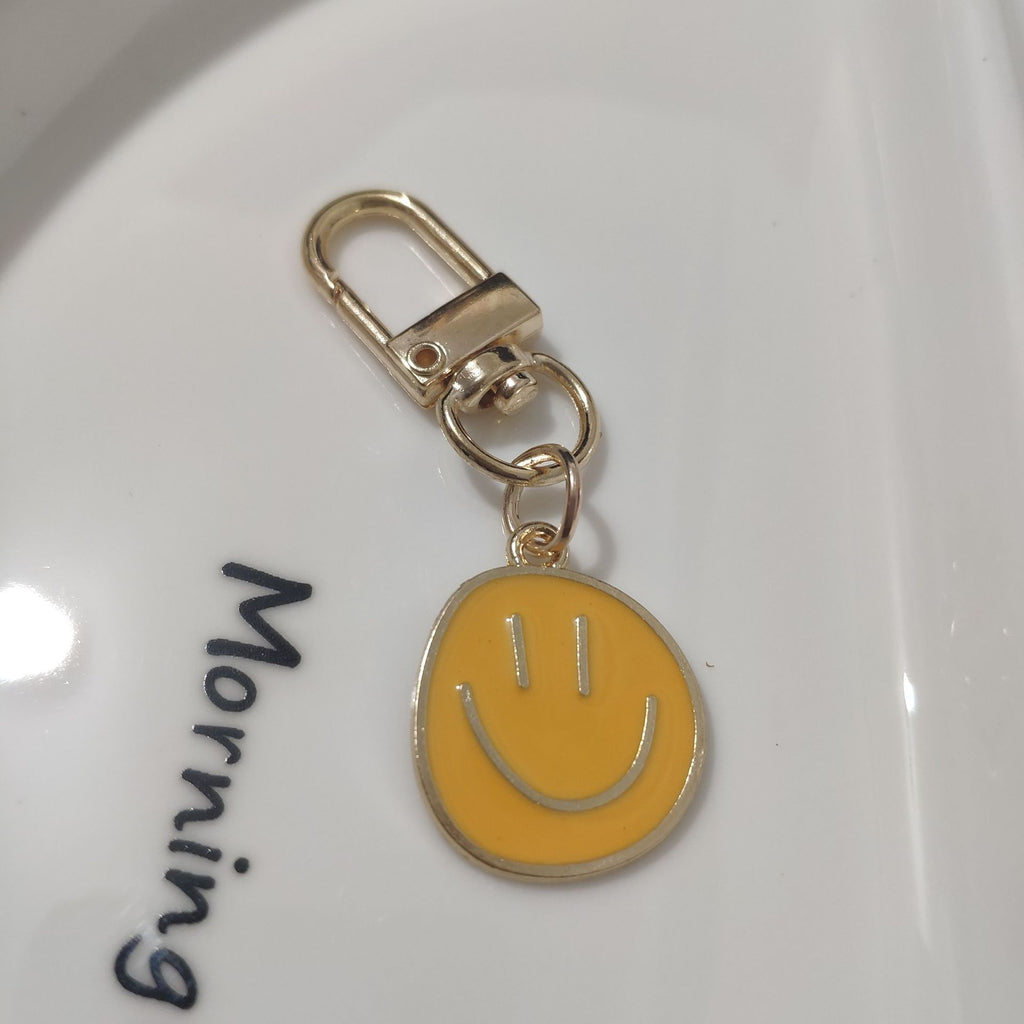 Cross-border e-commerce alloy color dripping smiley face keychain electroplated gold irregular expression bag pendant accessories